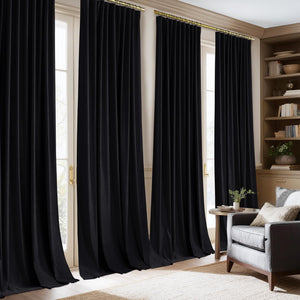 Luxurious black velvet pinch pleat curtains hanging from a gold rod in an elegant living room.