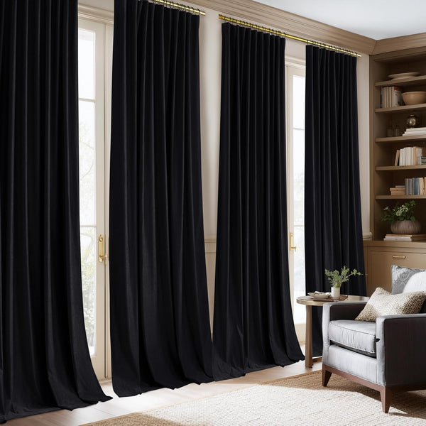 Luxurious black velvet pinch pleat curtains hanging from a gold rod in an elegant living room.