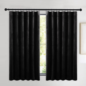Rich black velvet window curtains with a soft texture, hung on a black ring-top rod.