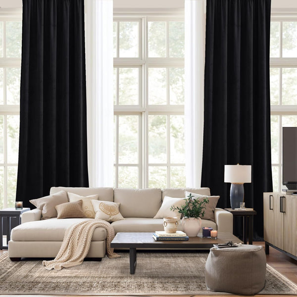Elegant black velvet rod pocket blackout curtains hanging in a bright living room.