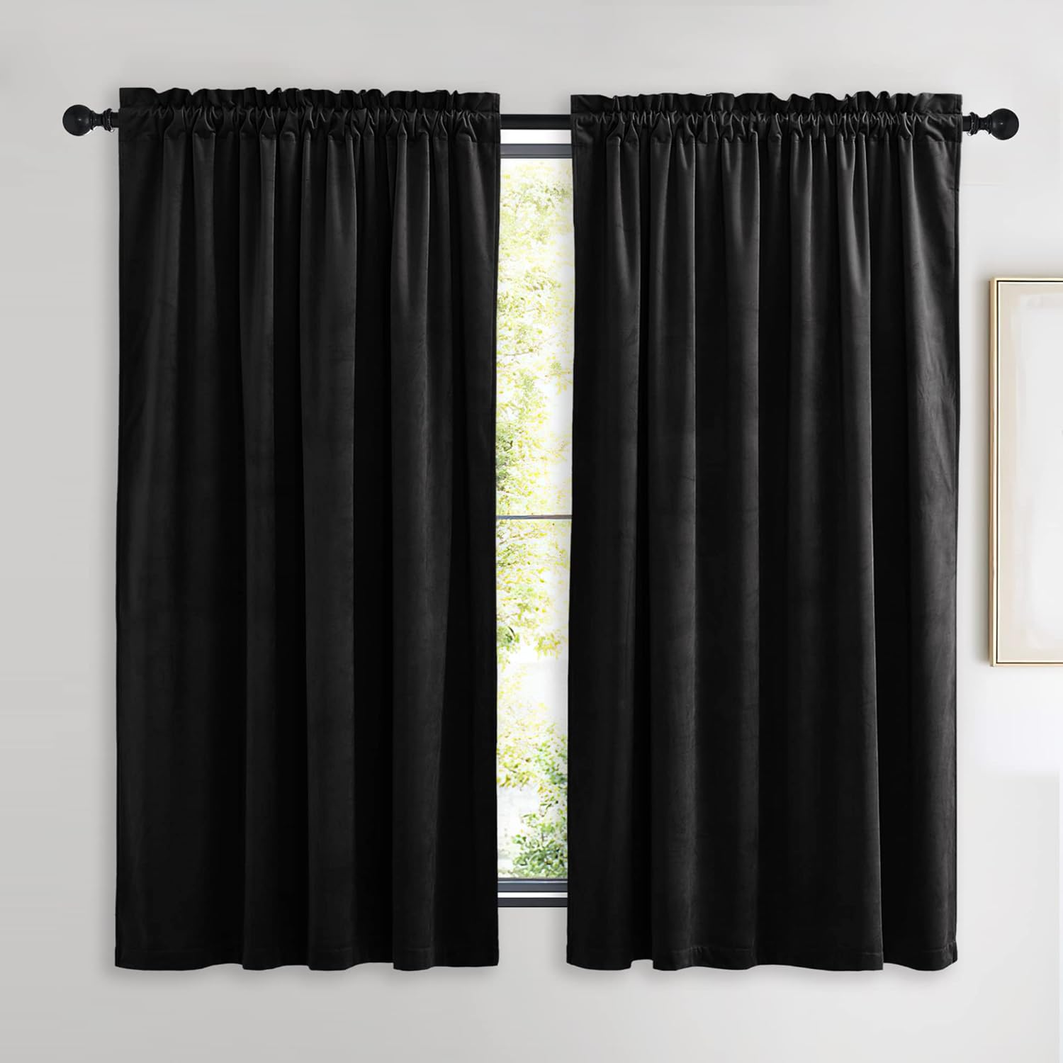 Two luxurious black velvet curtains with rod pocket top, fully drawn over a window, providing blackout.