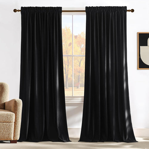 Pair of plush black velvet curtains with a gathered rod pocket top, hanging in a light-filled room.