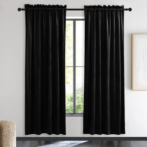 Elegant black velvet curtains with rod pocket top, draped on a dark rod in a modern room.