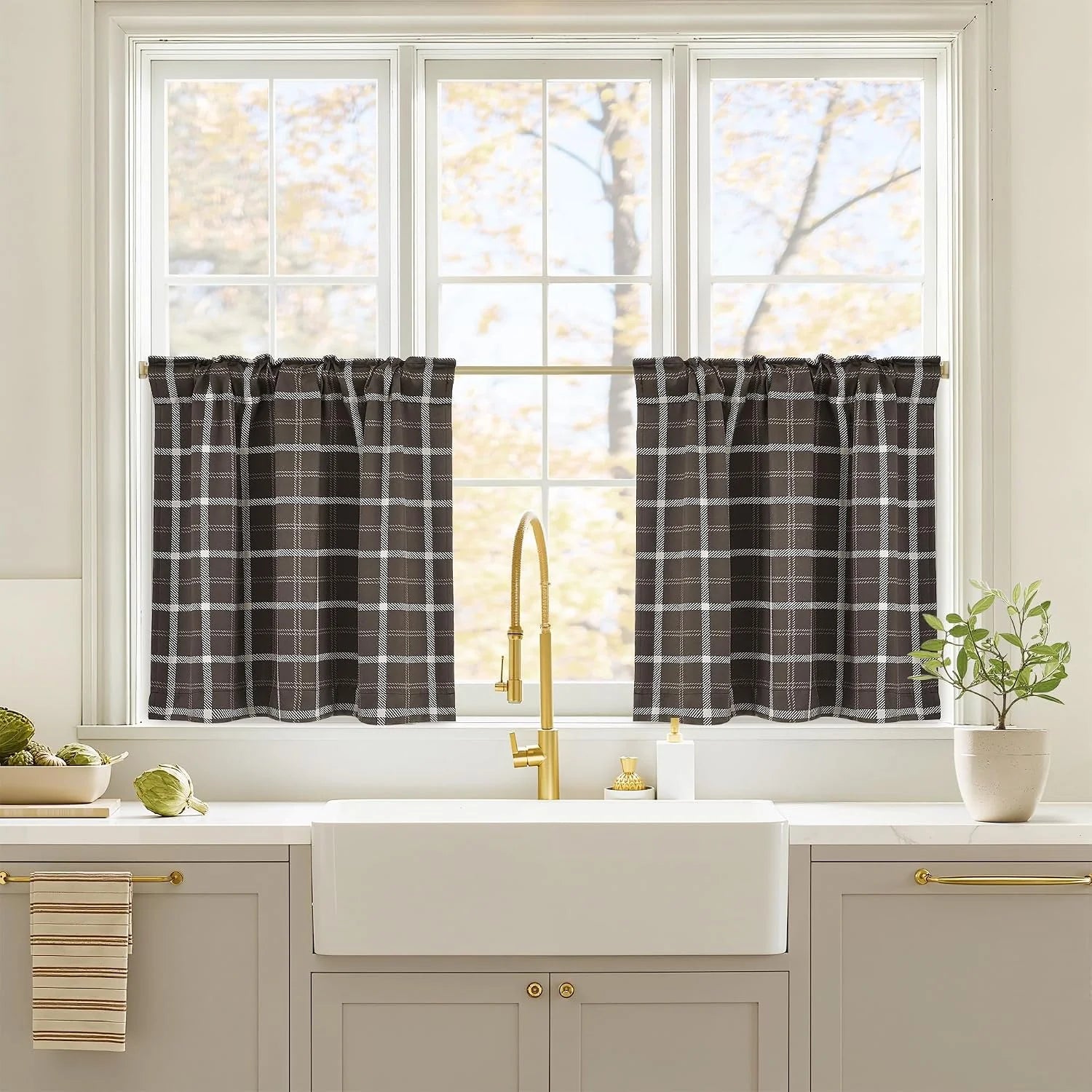Black and white plaid tier curtains over a bright kitchen sink window