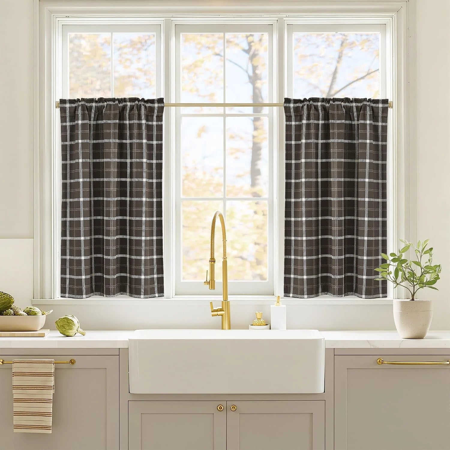 Black and white plaid tier curtains over a bright kitchen sink window