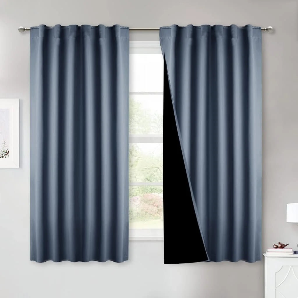 Blue blackout curtain panels on a silver rod, with one panel pulled back to show black lining