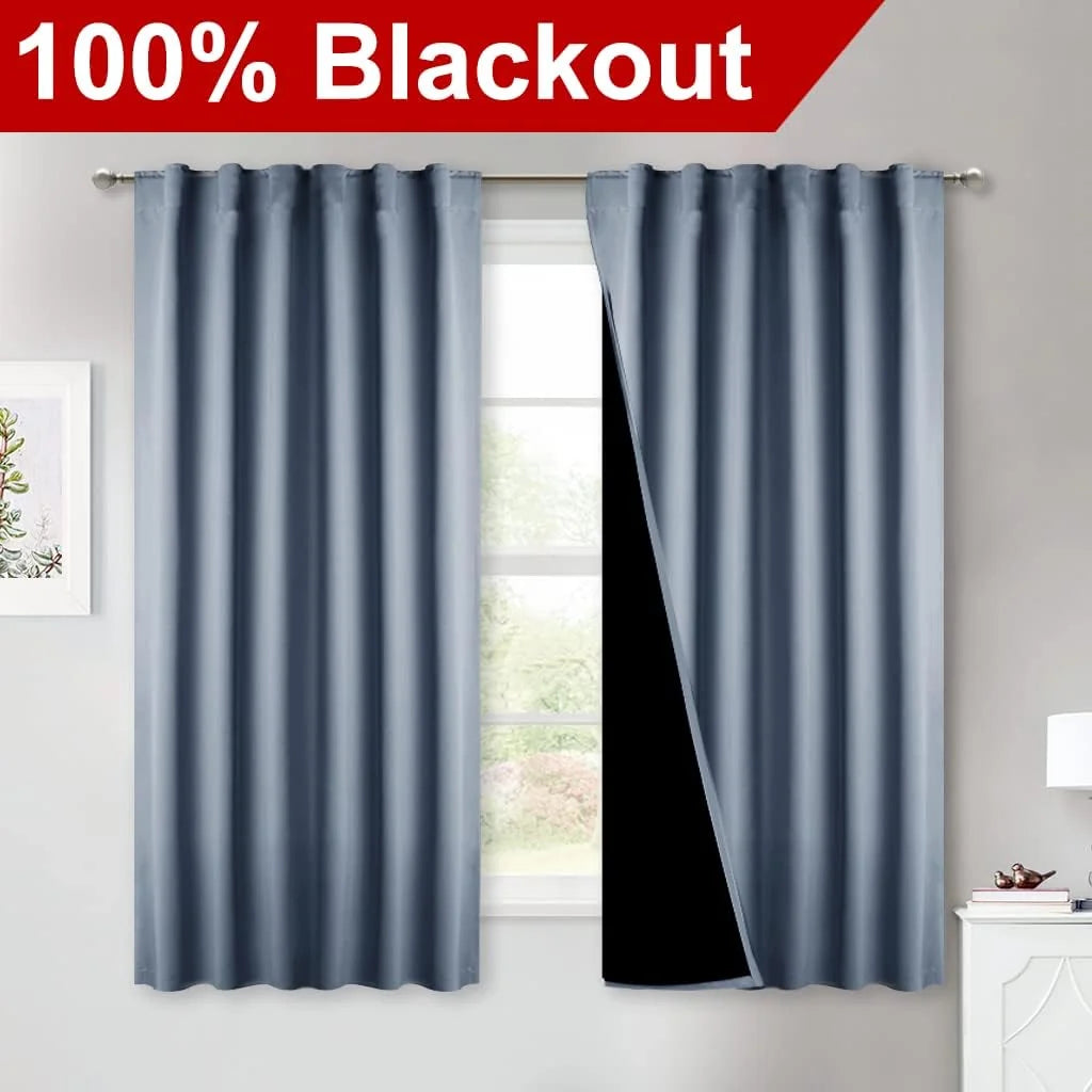 Light blue blackout curtains with rod pocket top and black lining over a bedroom window