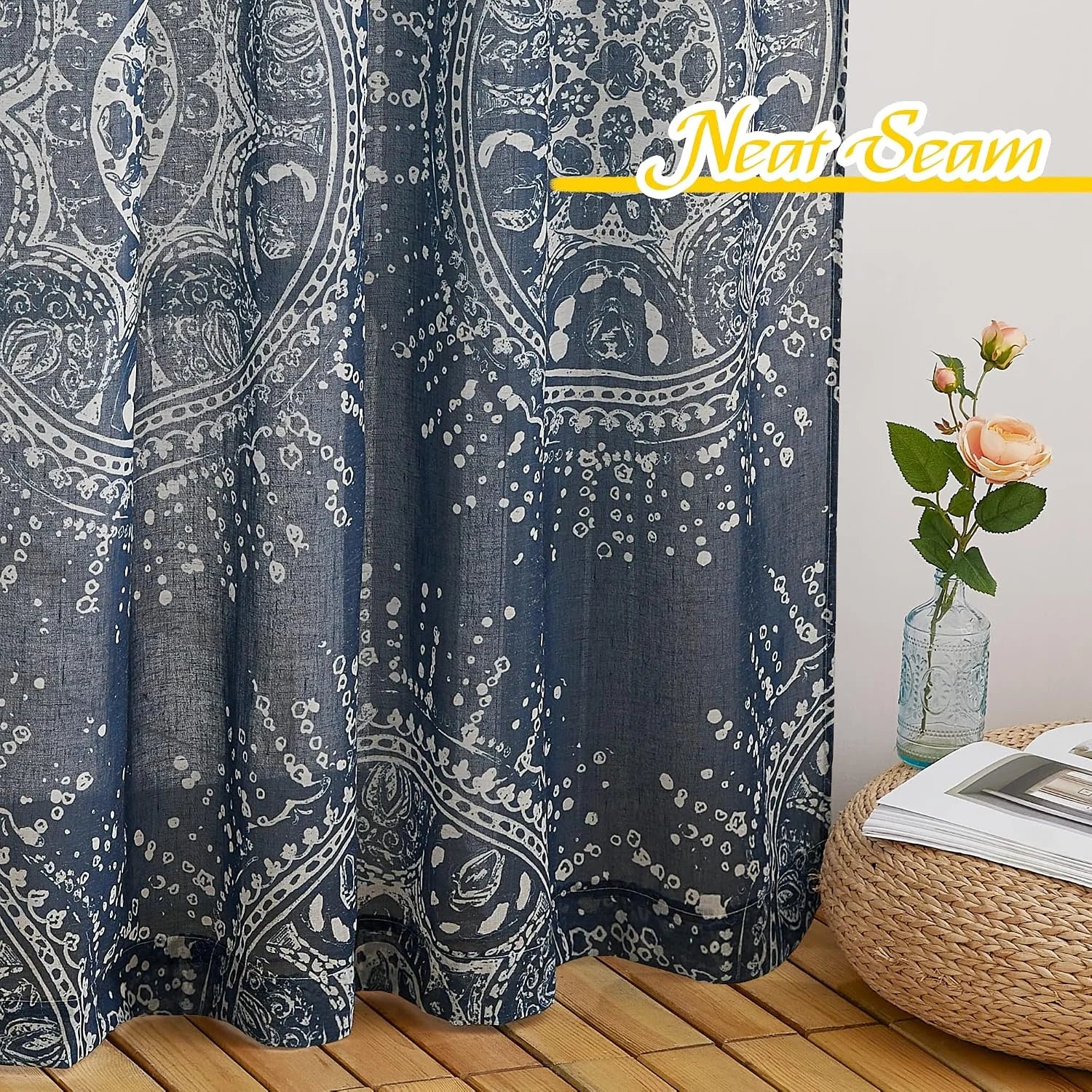 Blue patterned curtain panel with boho floral print beside woven stool and vase