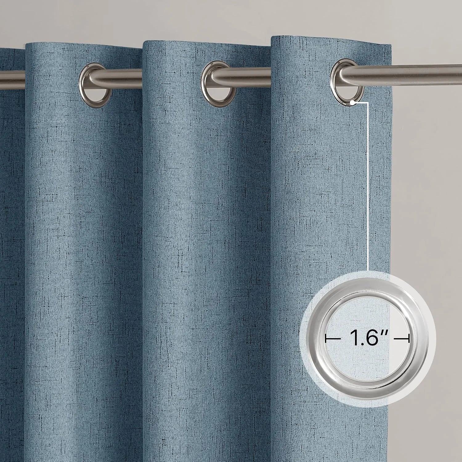 Blue textured curtain panel with silver grommet top on a brushed metal rod