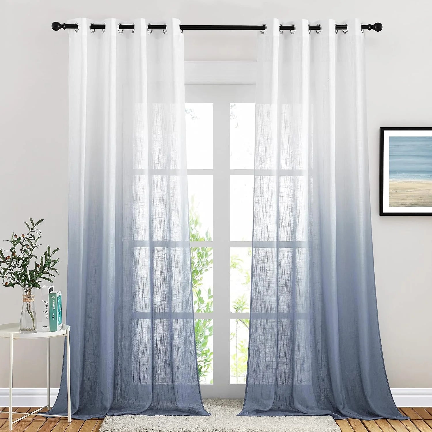 White to blue ombre sheer curtains with black grommets on a bright window