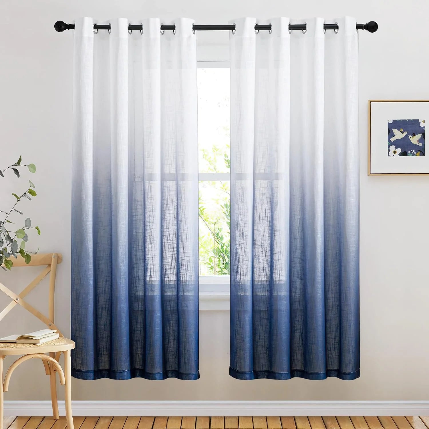 Blue ombre sheer curtains with silver grommets hanging in a bright modern room