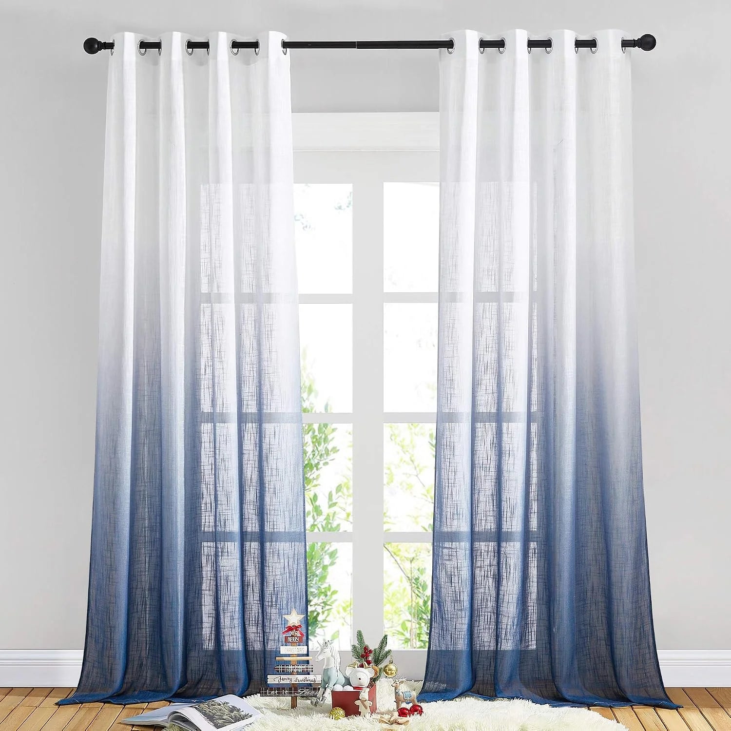 White to navy ombre sheer linen curtains with grommet top hanging over a tall window
