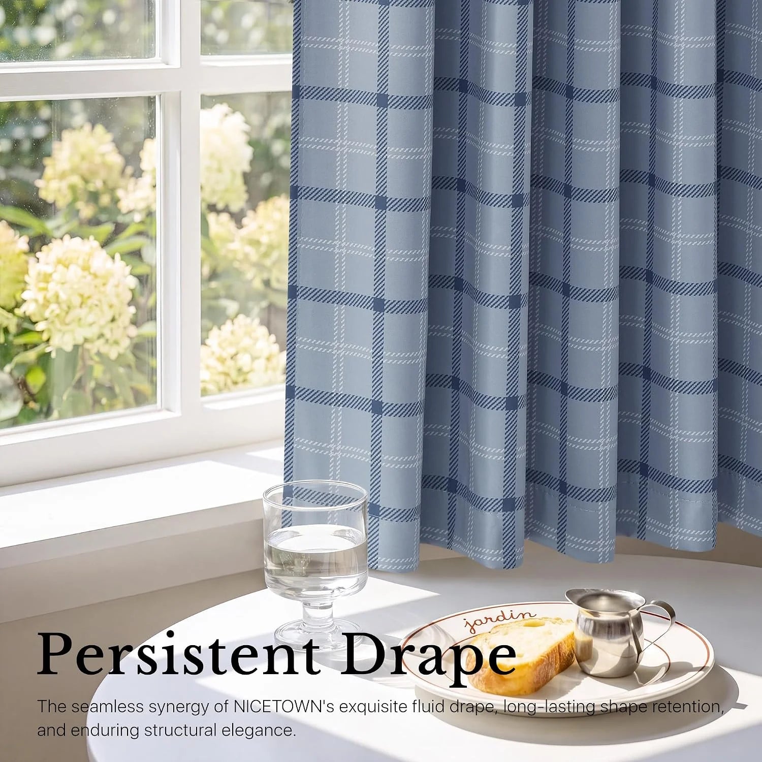 Blue plaid window curtain with soft drape beside a sunlit white framed window