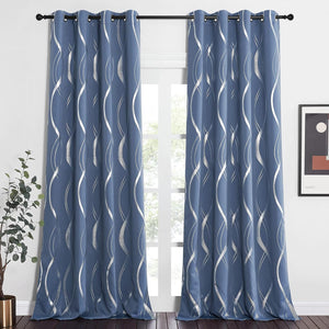 Modern slate blue grommet top curtains with shimmering silver wavy geometric pattern hanging by a window.