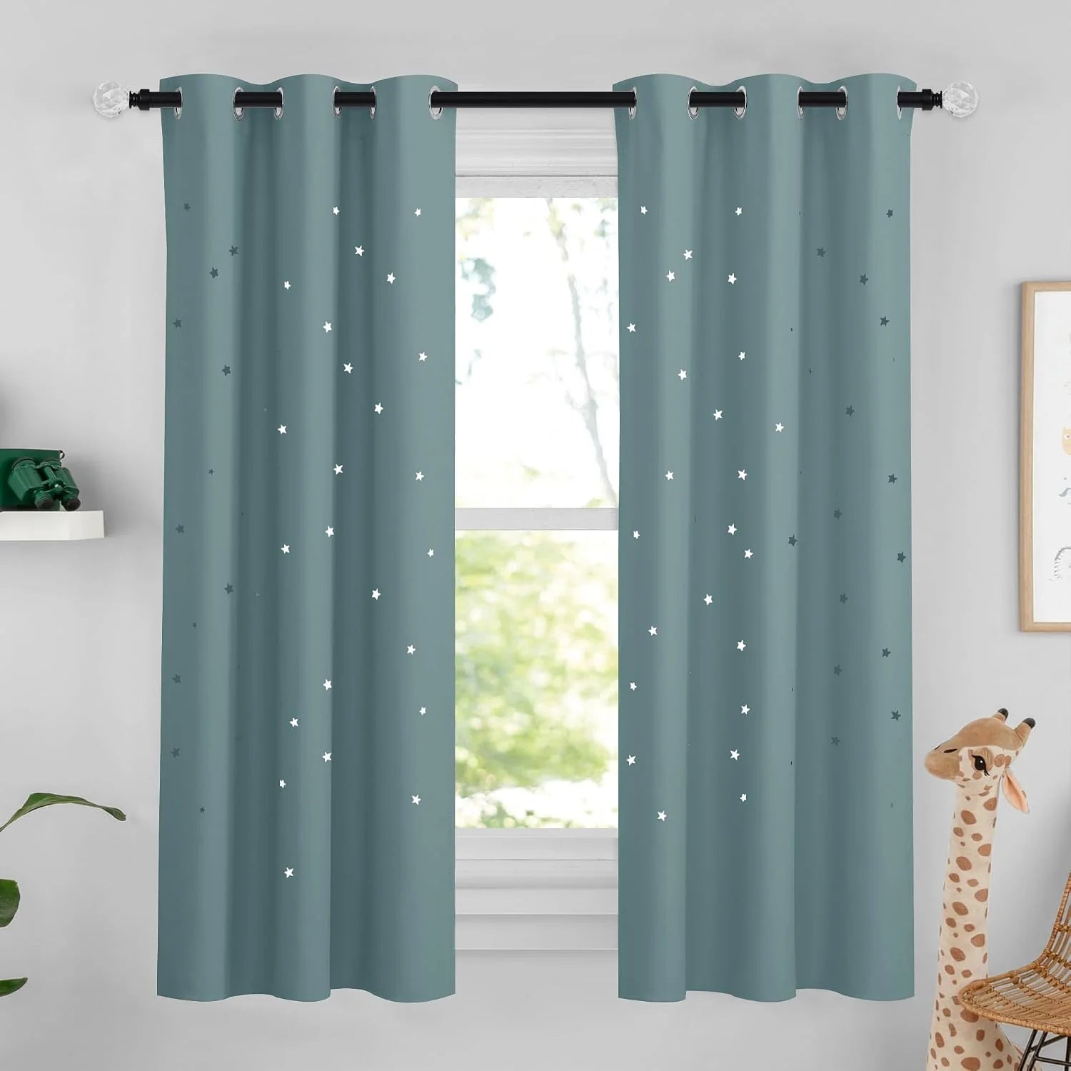 Dusty blue star-pattern grommet curtains hanging in a bright kids room window
