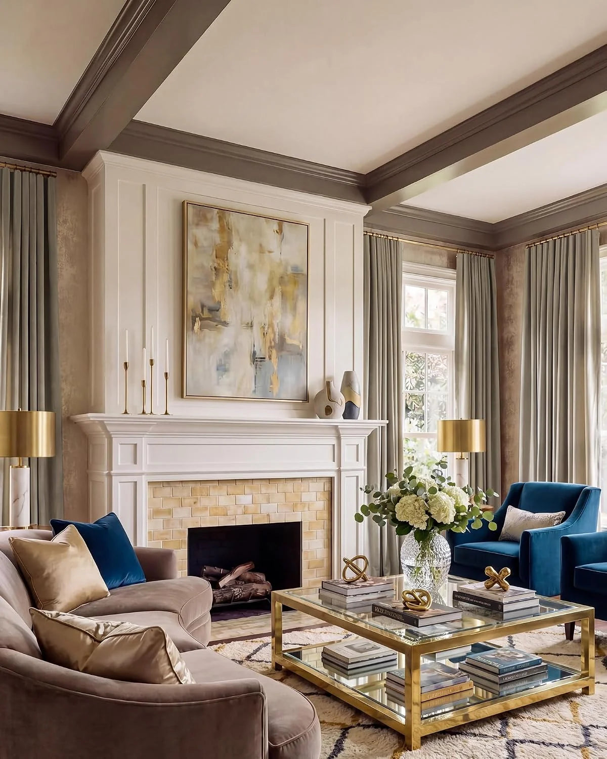 Elegant living room with blue velvet chairs, beige sofa, fireplace, and gold glass coffee table