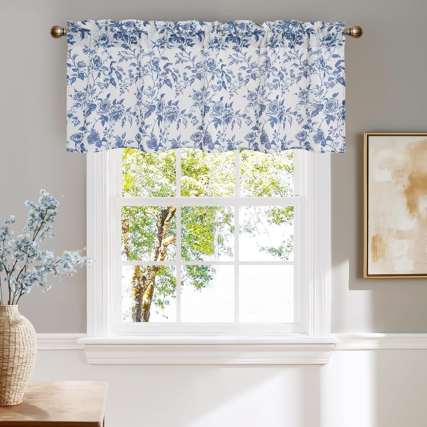 Gathered white window valance featuring a delicate blue floral rose pattern, hung on a bronze rod.