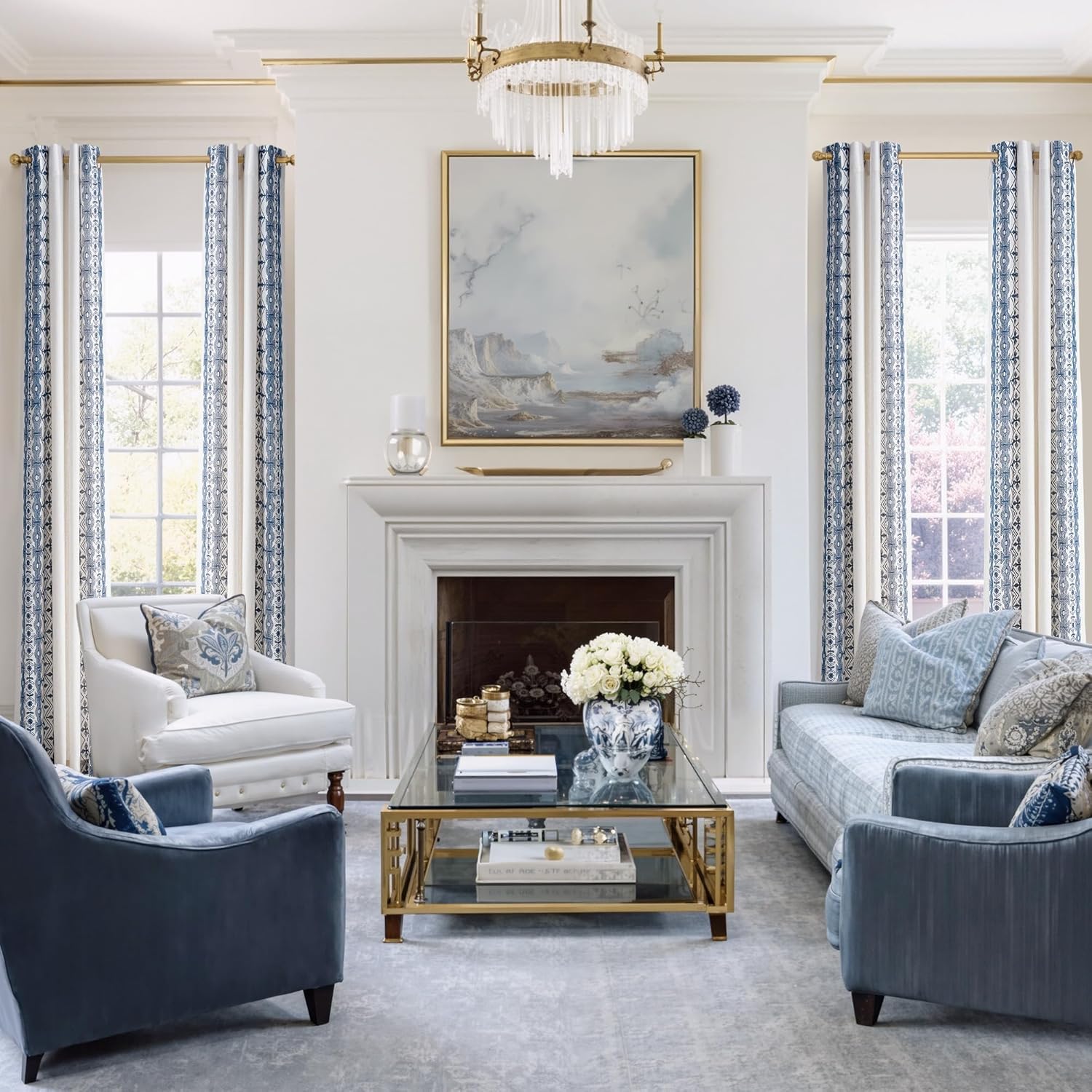 Blue and white geometric patterned grommet curtains hanging on a gold rod in a bright living room.