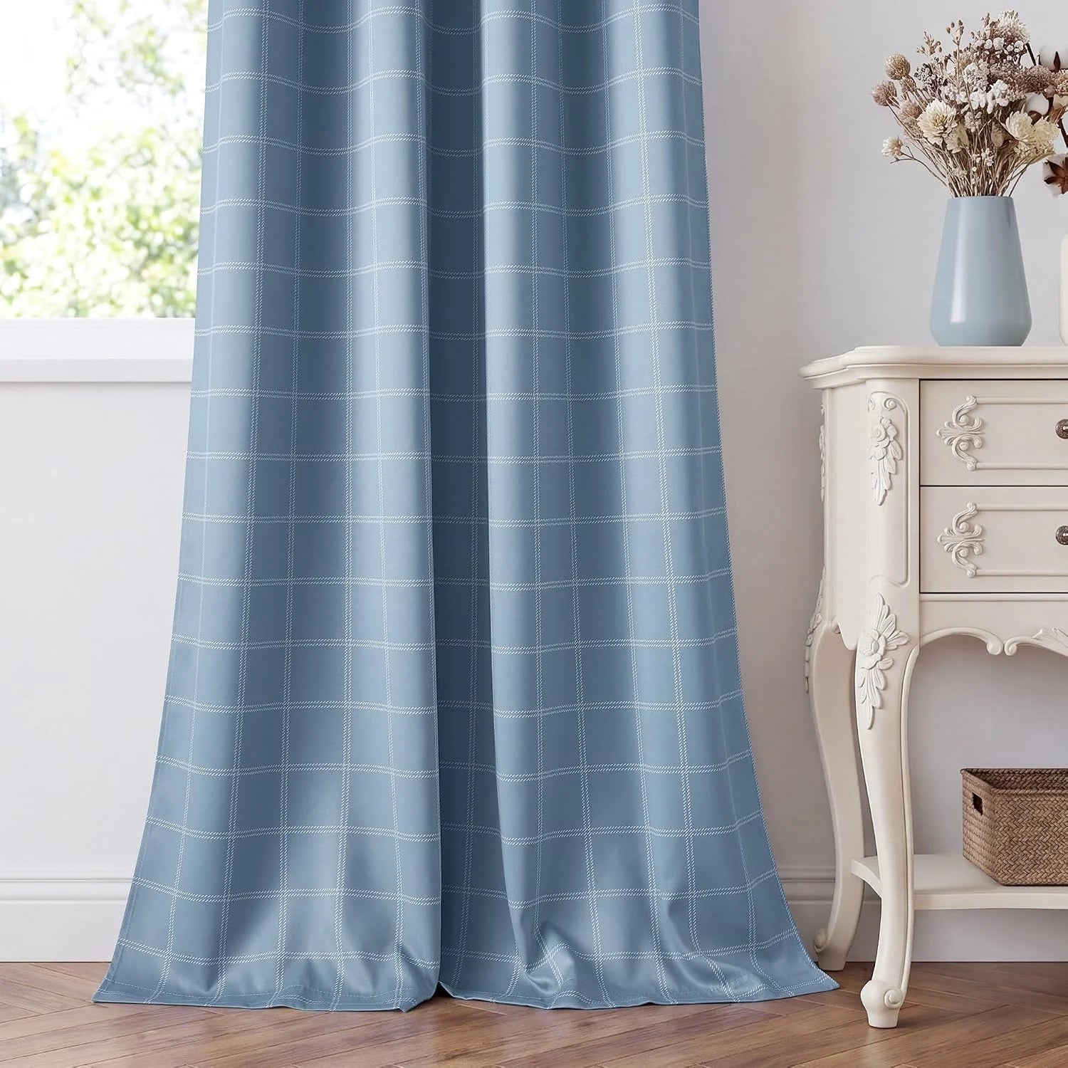 Light blue windowpane curtain panel beside a white ornate side table