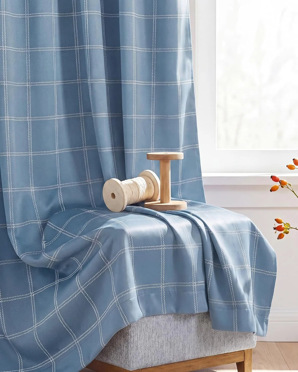Blue windowpane plaid fabric draped over a bench beside a bright white window