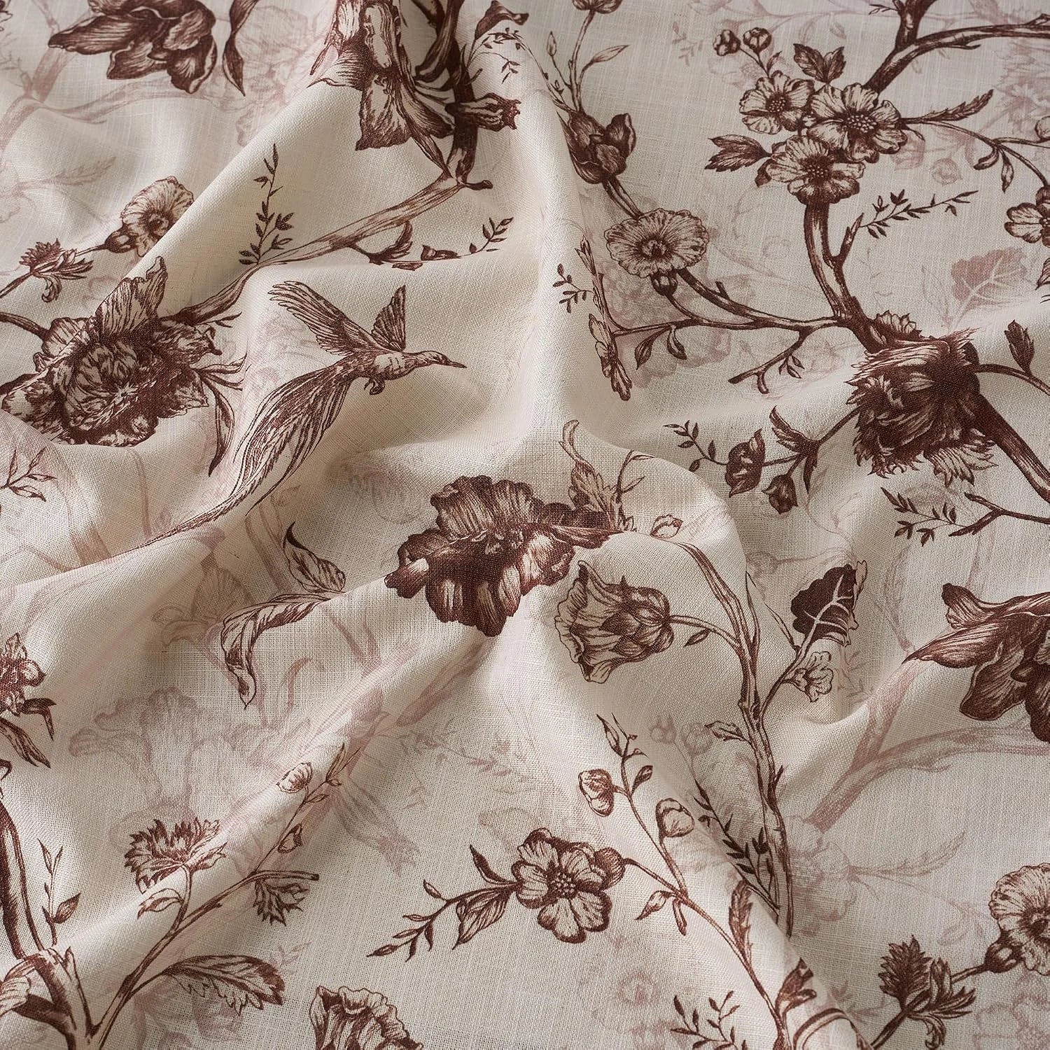 Soft blush fabric with brown floral branches and bird toile print draped in folds