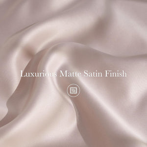 Close-up of luxurious blush matte satin fabric showing elegant drapes and a smooth, soft finish.