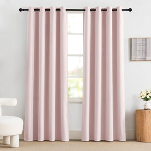 Two panels of blush pink blackout grommet curtains hanging on a black rod, covering a window in a modern room.