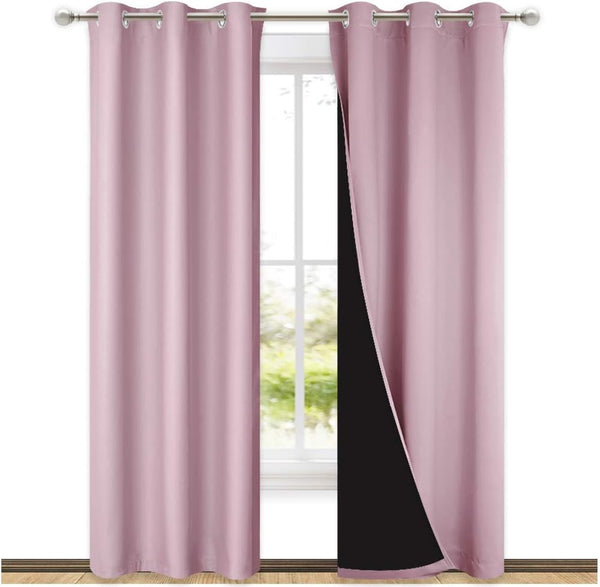 Blush pink blackout curtains with silver grommets on a rod. The visible dark lining confirms room darkening.
