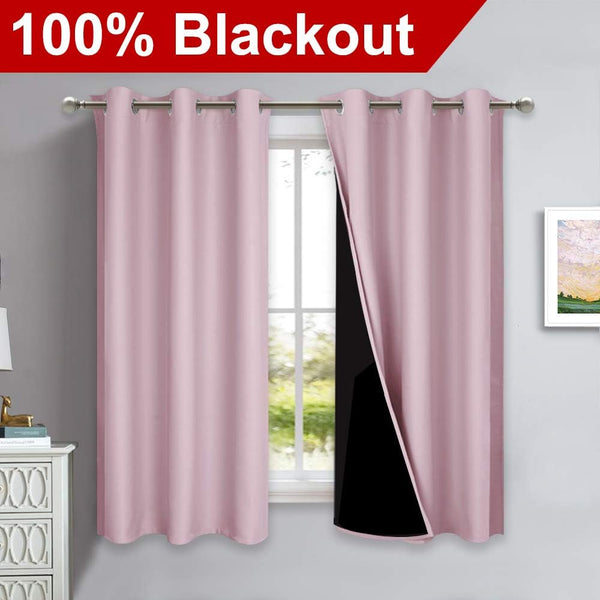 Pair of blush pink blackout curtains with silver grommets, one panel revealing black thermal lining.