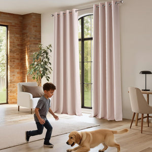 Blush pink linen-look grommet curtains hanging on a silver rod over large arched windows in a modern living room.