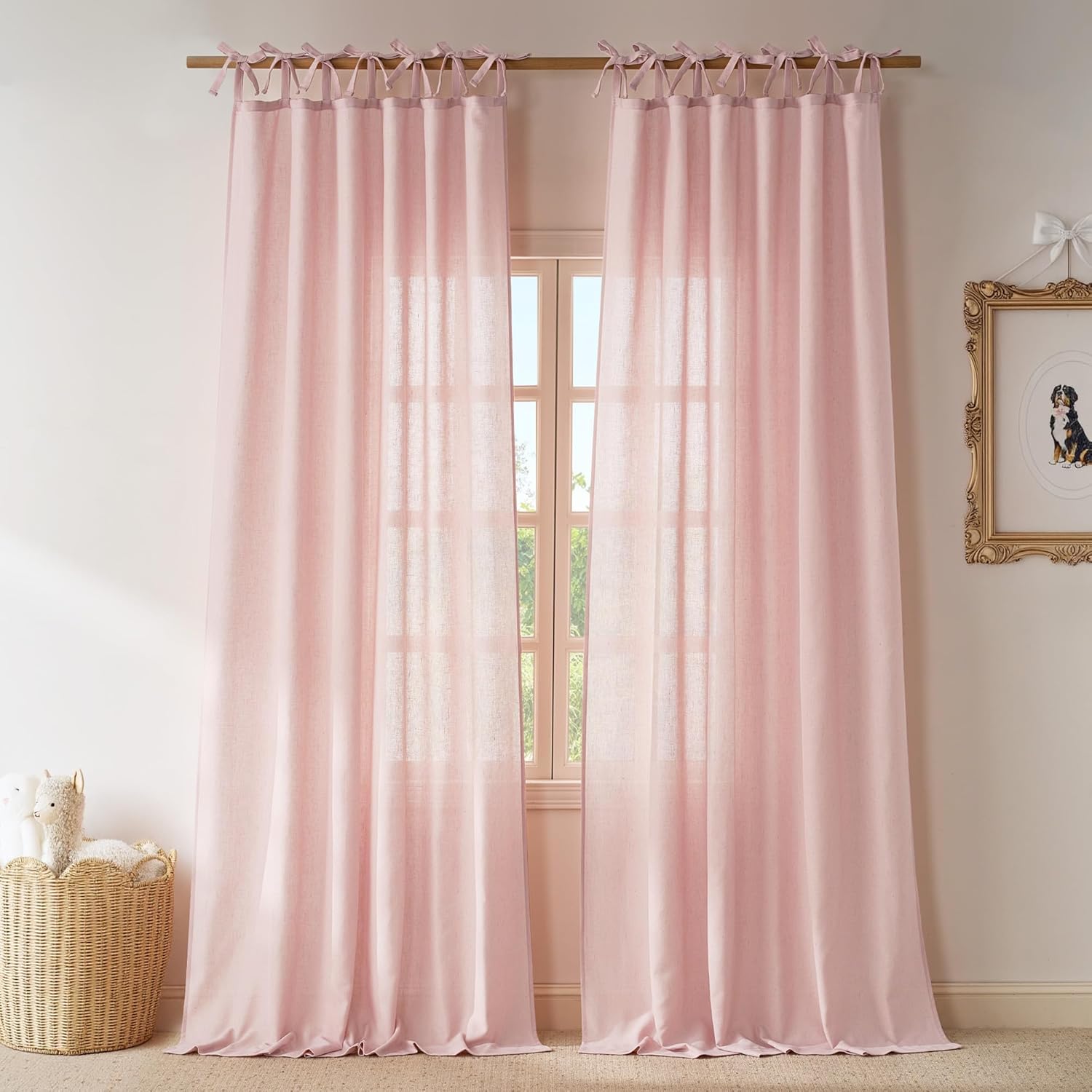 Blush pink linen-blend curtains with tie-top bows, gently filtering sunlight in a room.
