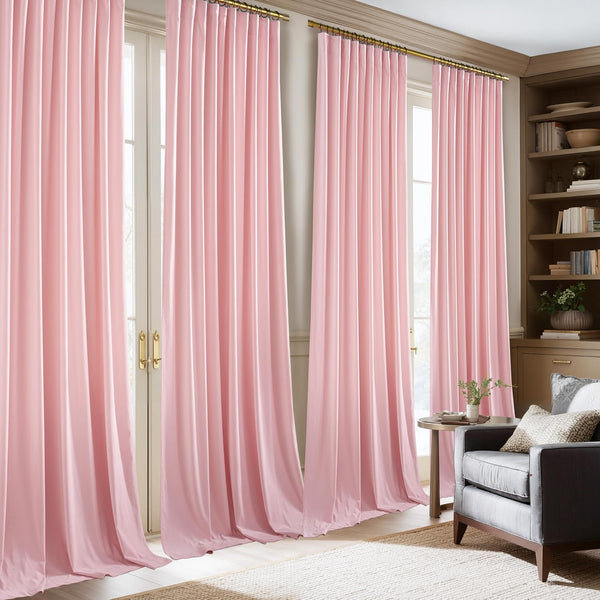 Blush pink pinch pleat curtains on a gold rod, floor-length and draped over large windows.