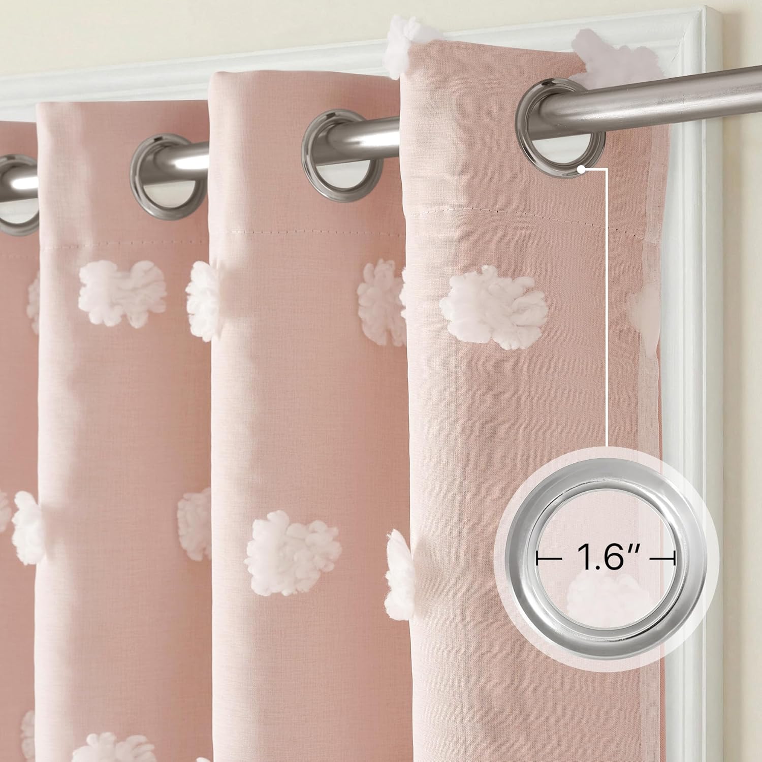 Blush pink curtains with white pom-pom tufts and silver grommet tops. Grommet diameter is 1.6 inches.