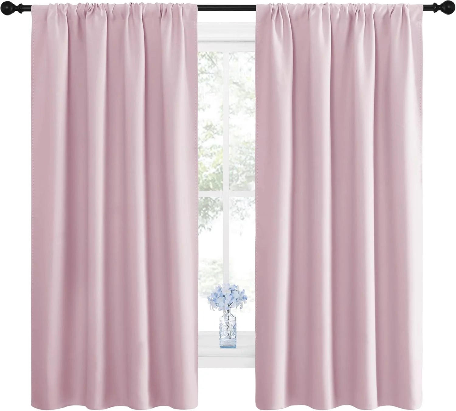 Pair of blush pink rod pocket curtains on a black rod, framing a window with a vase of blue flowers on the sill.