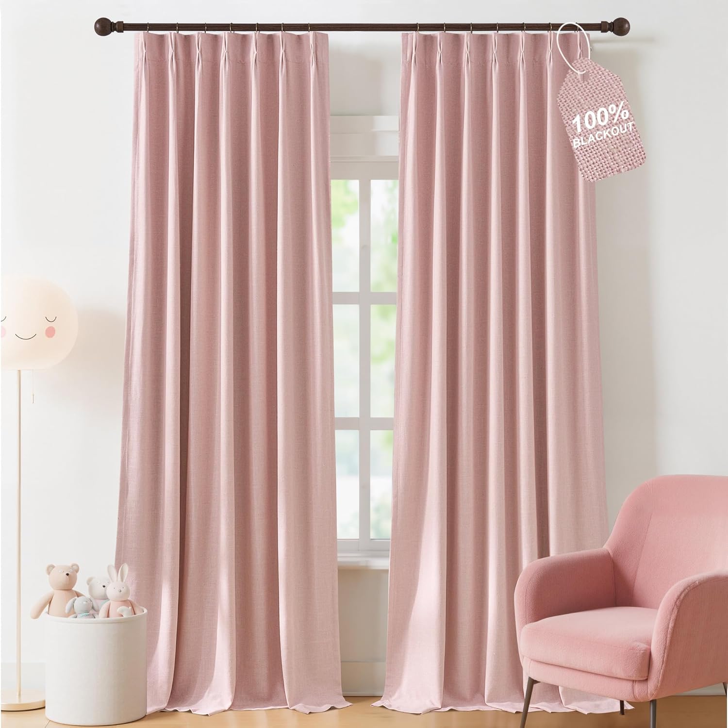 Blush pink textured pinch pleat curtains hanging on a dark brown rod with 100% blackout tag.