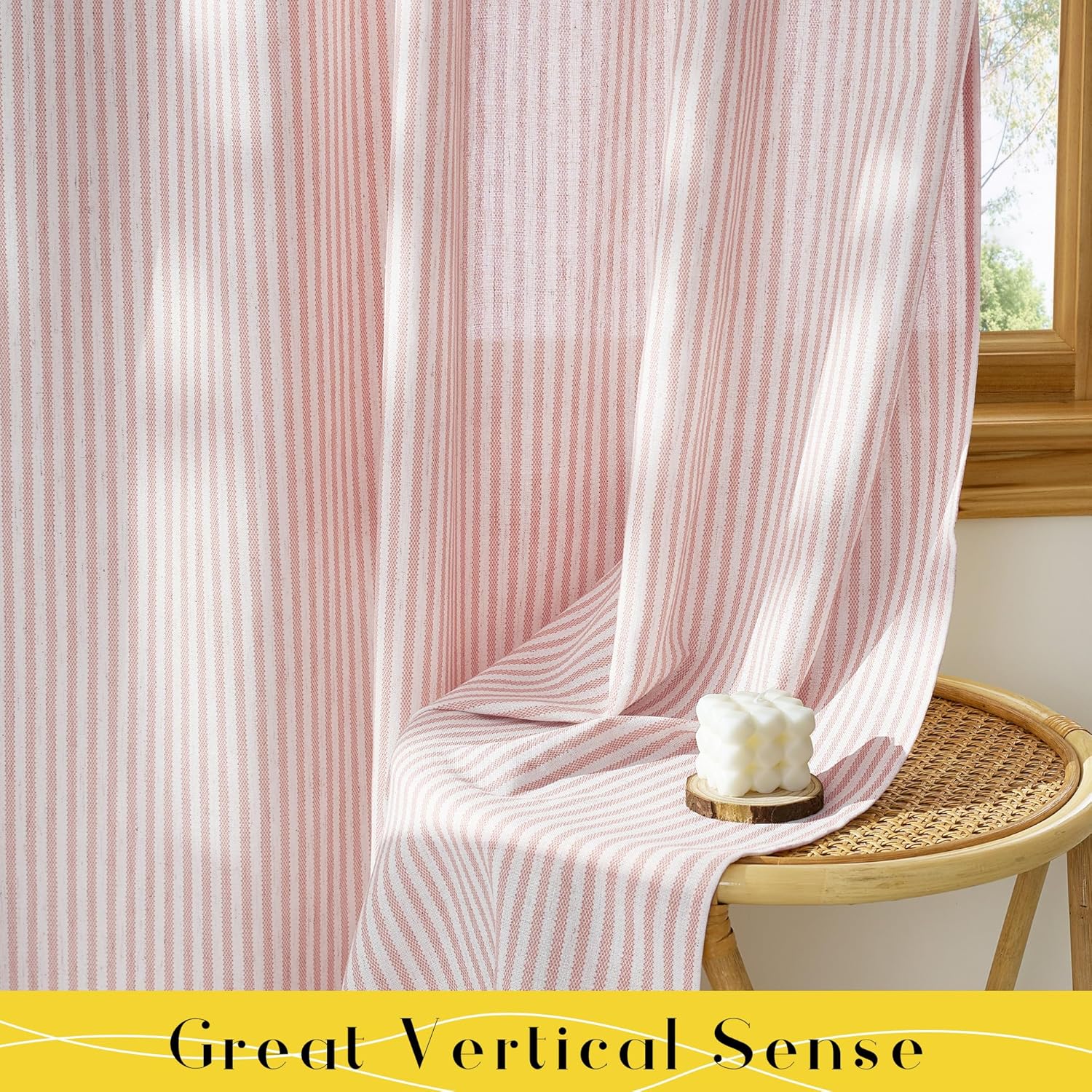 Blush pink and white textured vertical striped curtains hanging by a window next to a rattan stool.