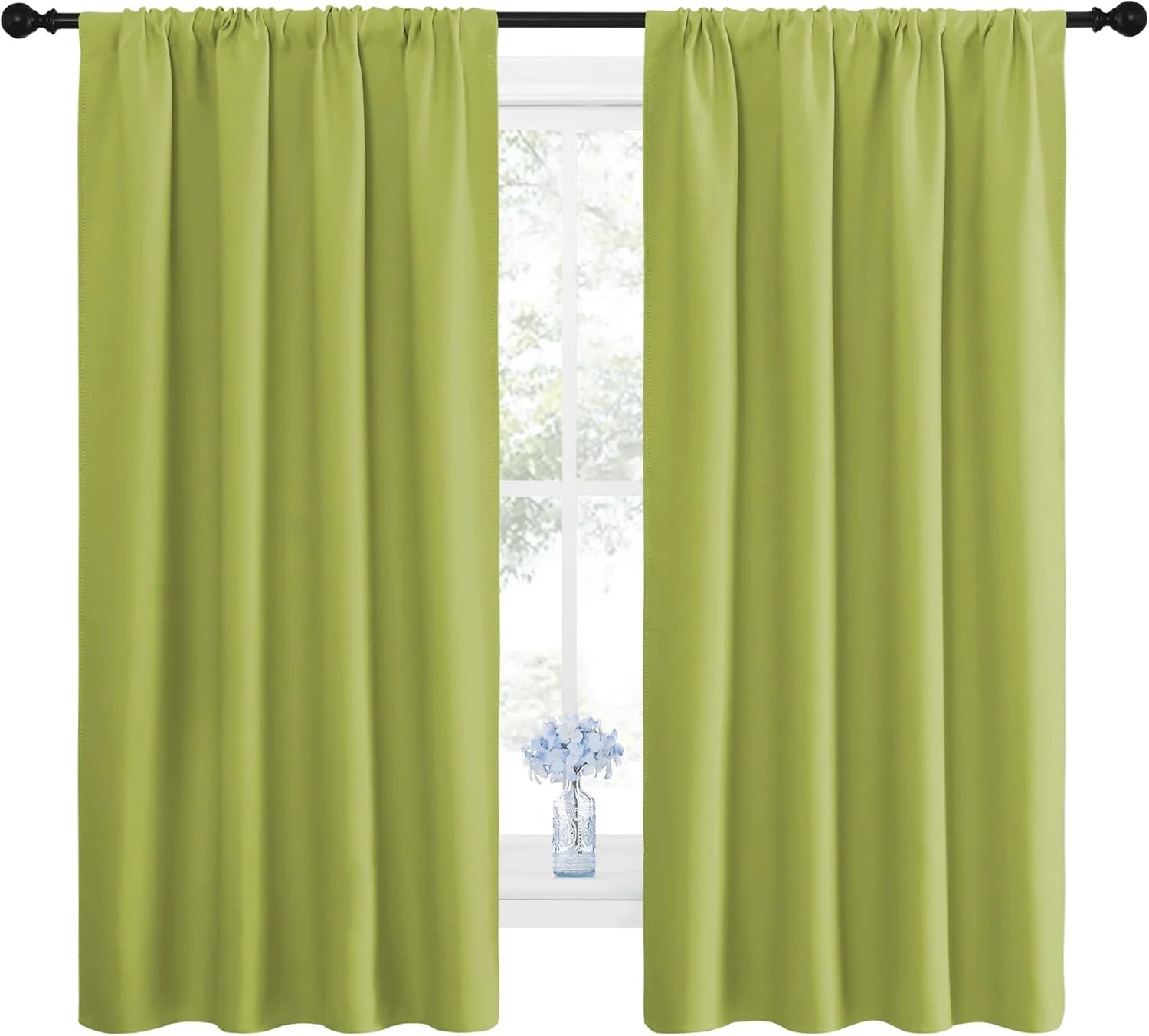 Pair of bright green rod pocket blackout curtains hanging on a window with a vase of blue flowers on the sill.