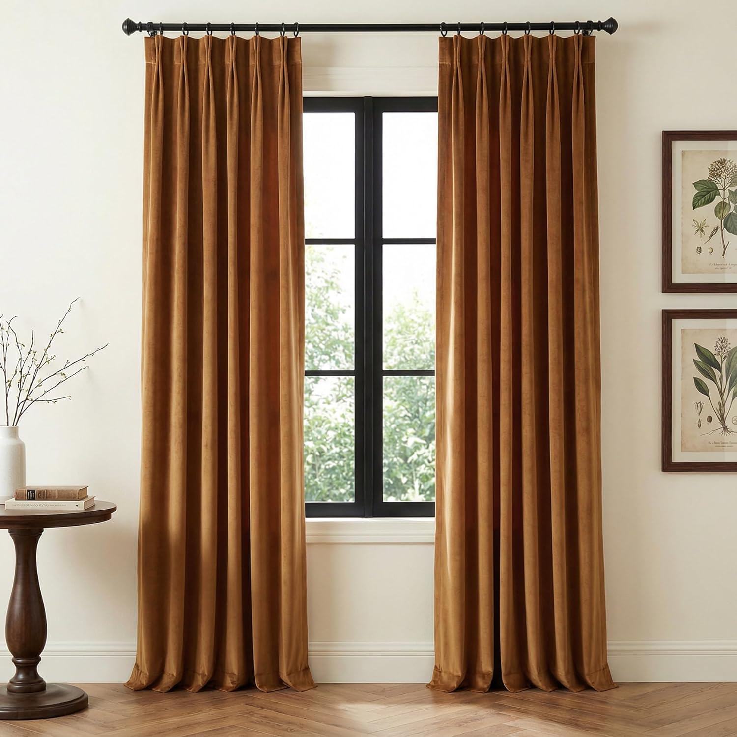 Elegant bronze velvet pinch pleat curtains hang from a black rod, framing a window in a sophisticated room.
