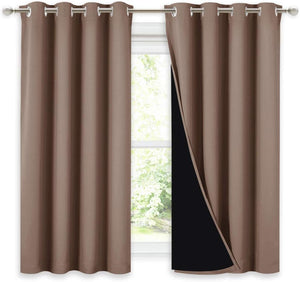 Pair of brown blackout curtains with silver grommets on a rod, one revealing its dark lining.