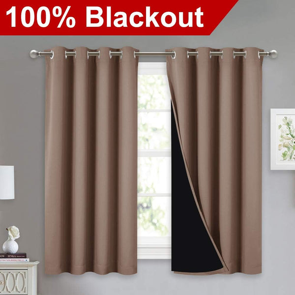 Brown blackout curtains with grommet top, two panels, revealing black lining, hanging over a window.