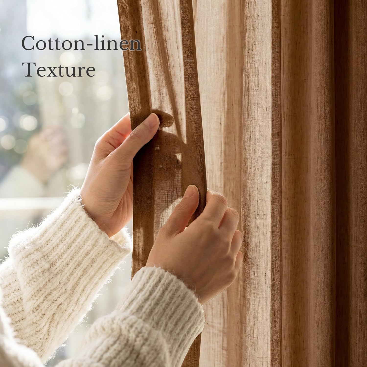 Close-up of hands holding a brown cotton linen sheer curtain, showcasing its visible texture.