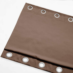 Close up of a solid brown curtain panel with silver metal grommets along the top for easy hanging.