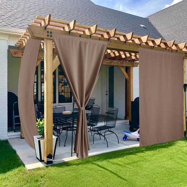 Brown outdoor privacy curtains with grommet tops draped on a wooden pergola, shading a patio seating area.