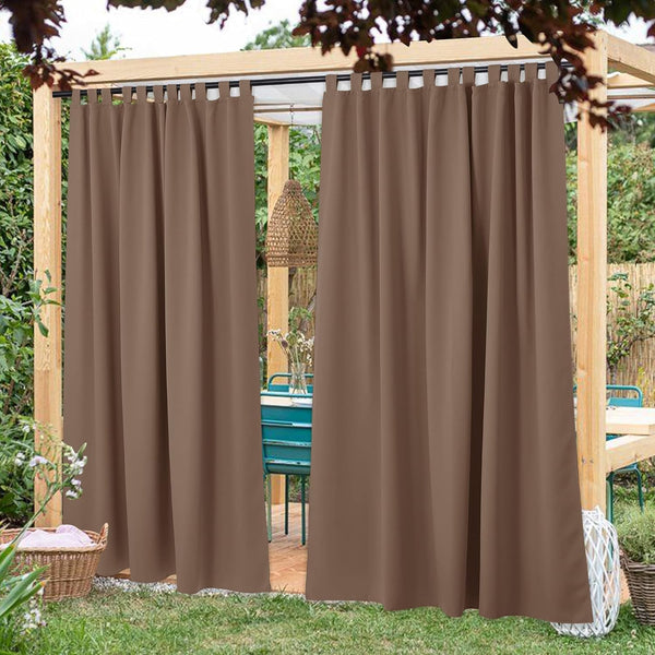 Brown tab top outdoor curtains hanging on a wooden pergola, providing shade and privacy for a patio dining area.