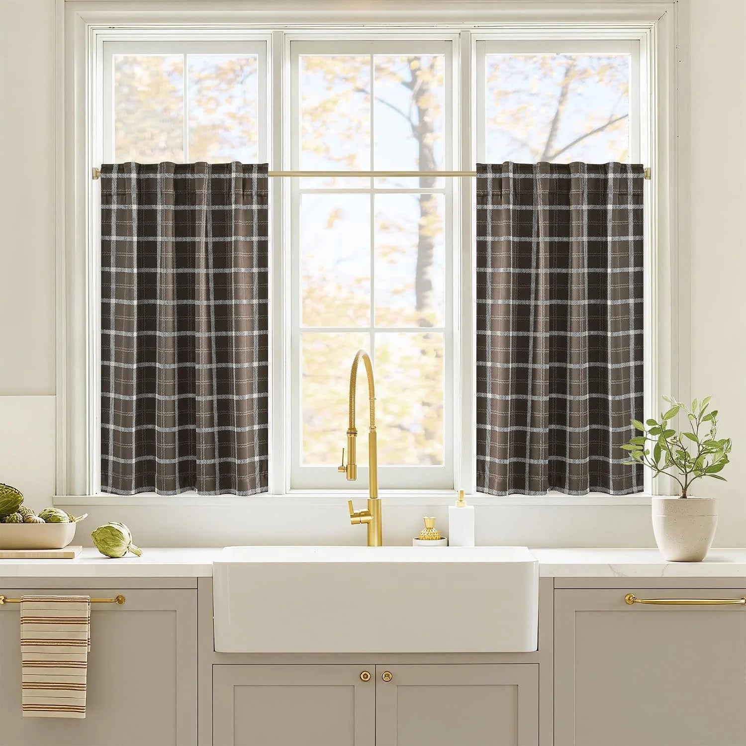 Brown and white plaid cafe curtains on a kitchen window above a farmhouse sink