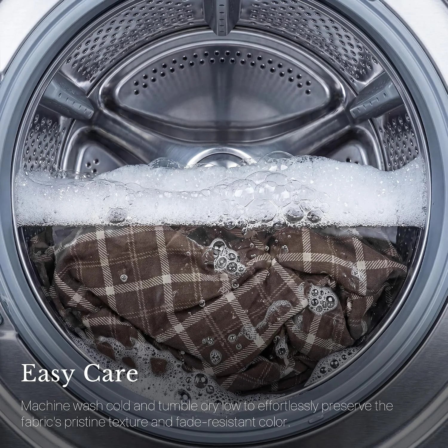 Brown plaid fabric inside a front-load washing machine with soap suds