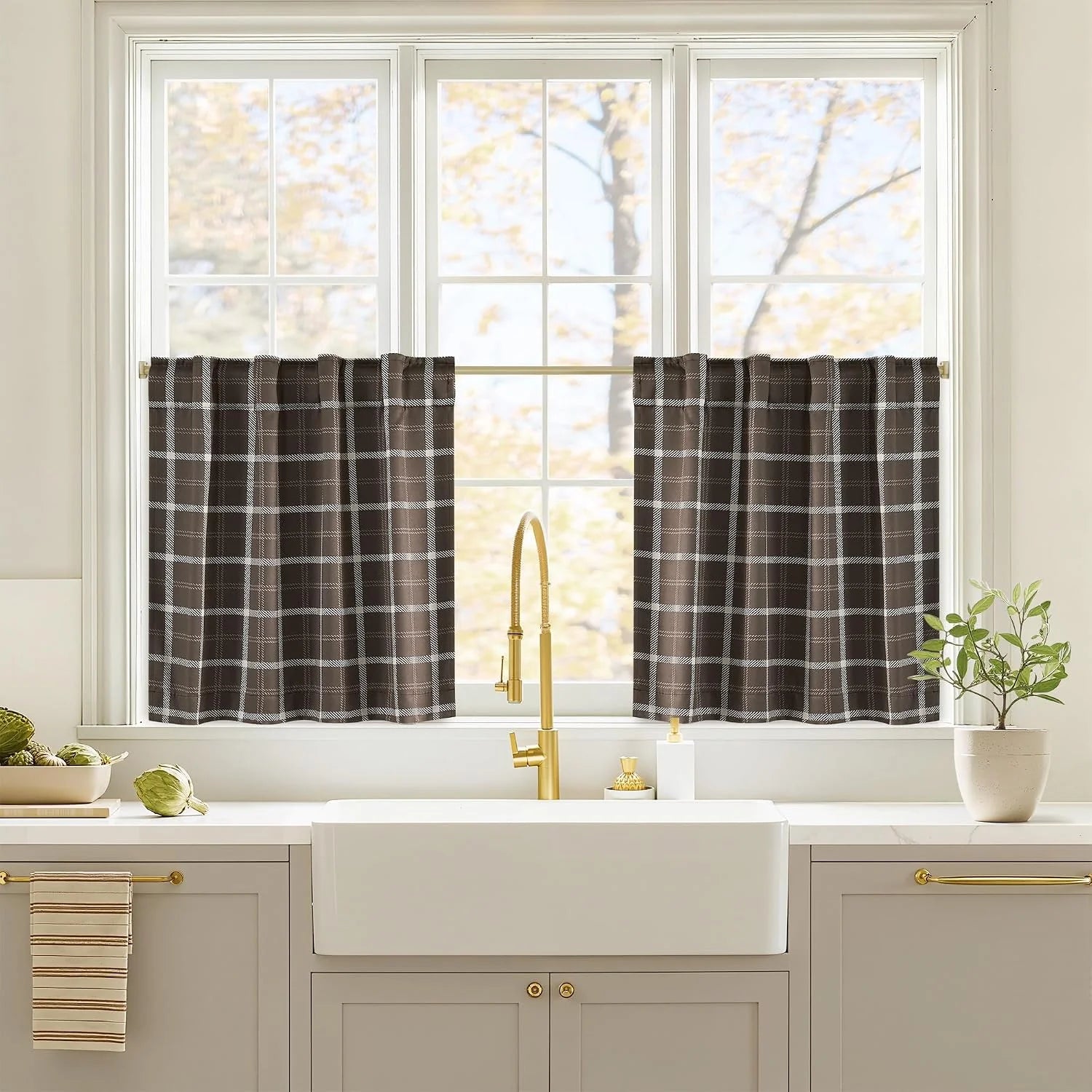 Brown plaid tier curtains on a white kitchen window above a farmhouse sink