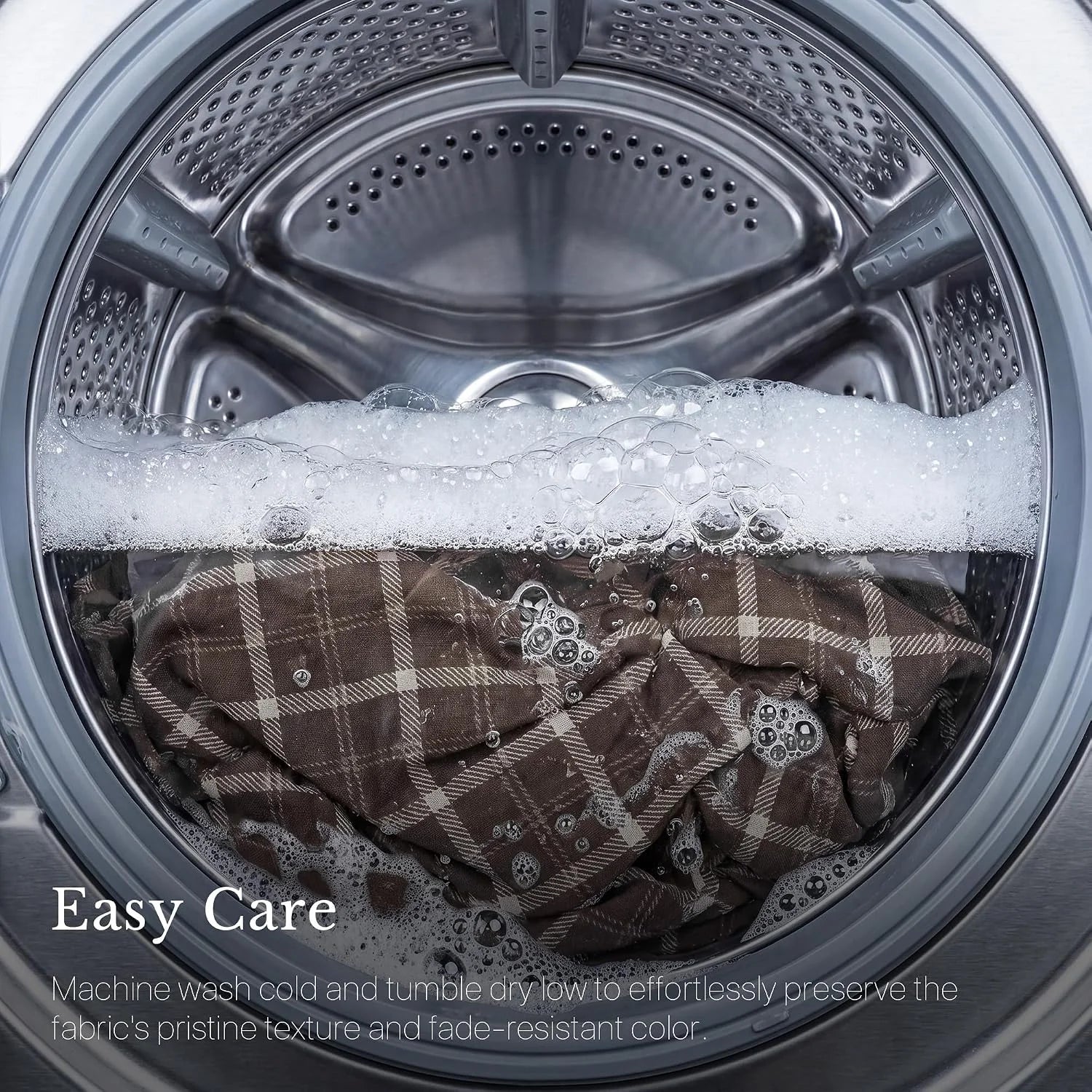 Brown plaid fabric in a front-load washing machine with soap bubbles and easy care text