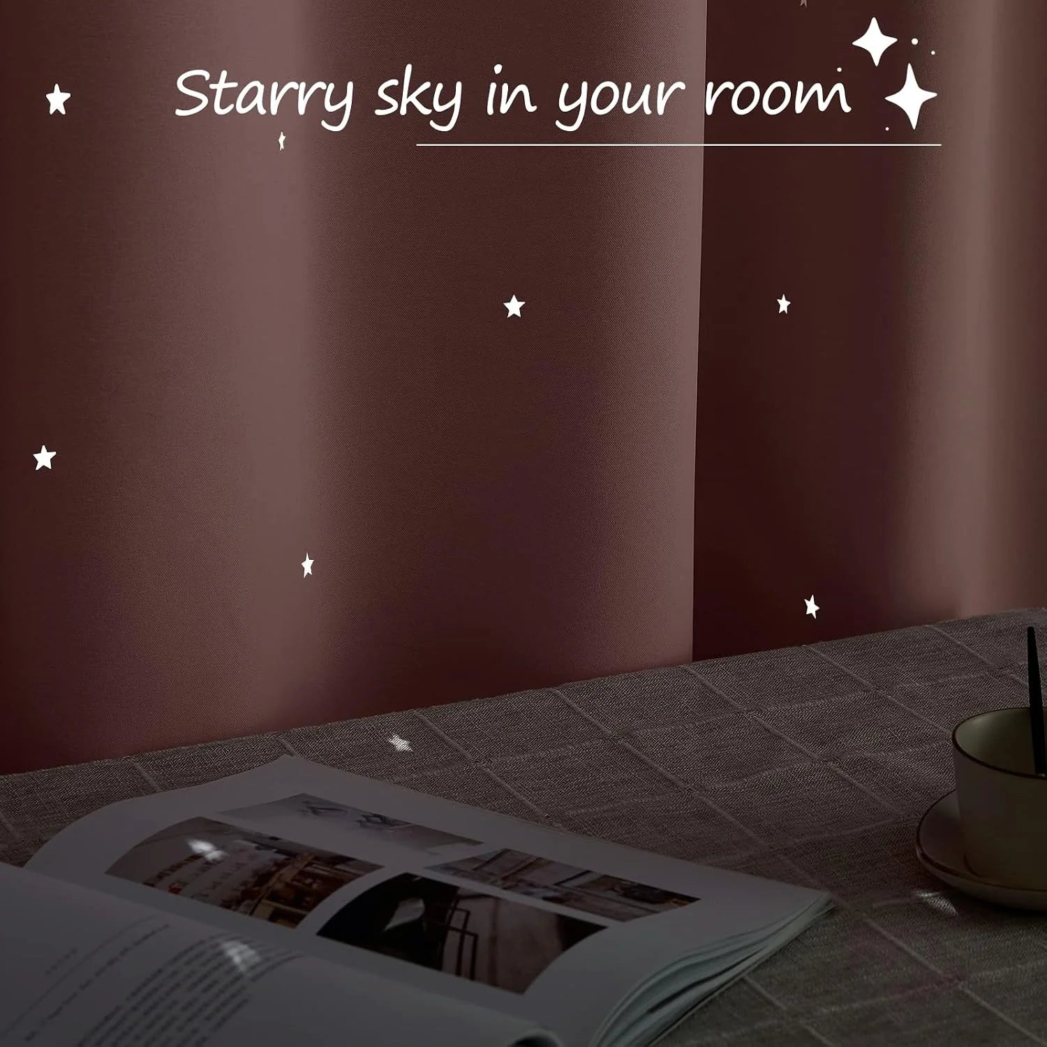 Brown curtain panel with glowing star cutouts above a table with book and cup