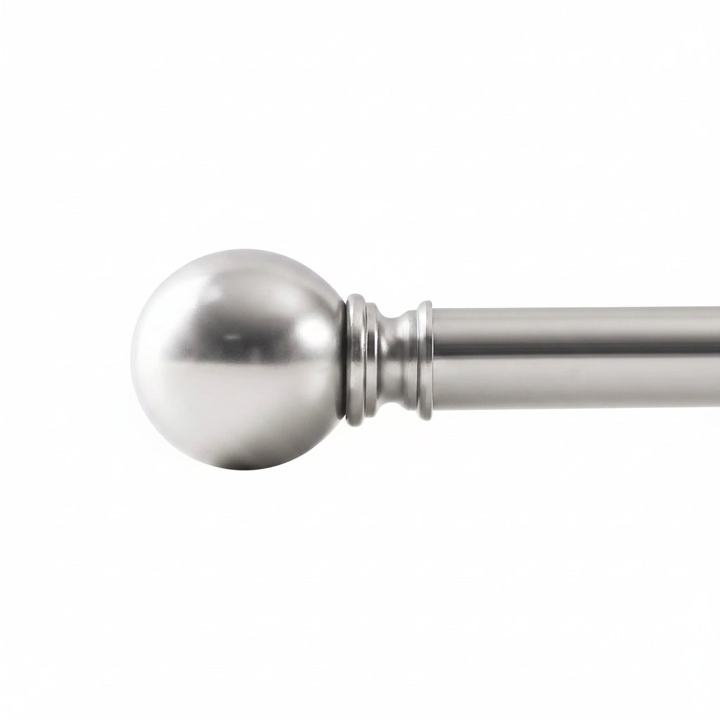 Close-up of a brushed nickel curtain rod with round ball finial and smooth metal finish